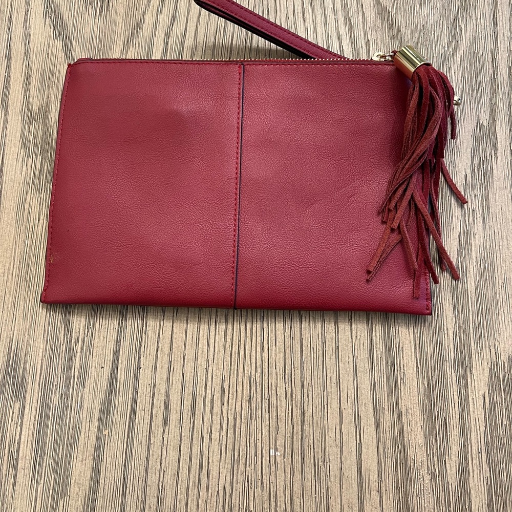 INC leather wristlet with side suede tassel & zipper closure.